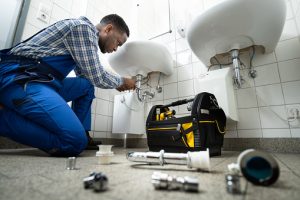 Plumber Fixing Pipe In Bathroom